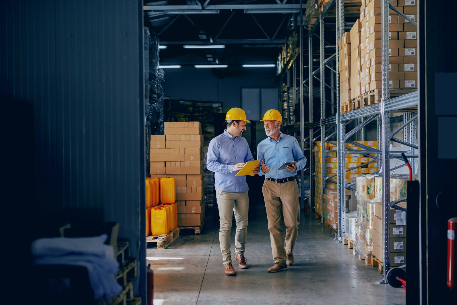 Two team members reviewing documents in a warehouse